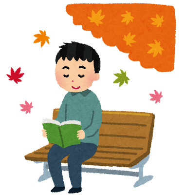 秋の公園のベンチで読書する人