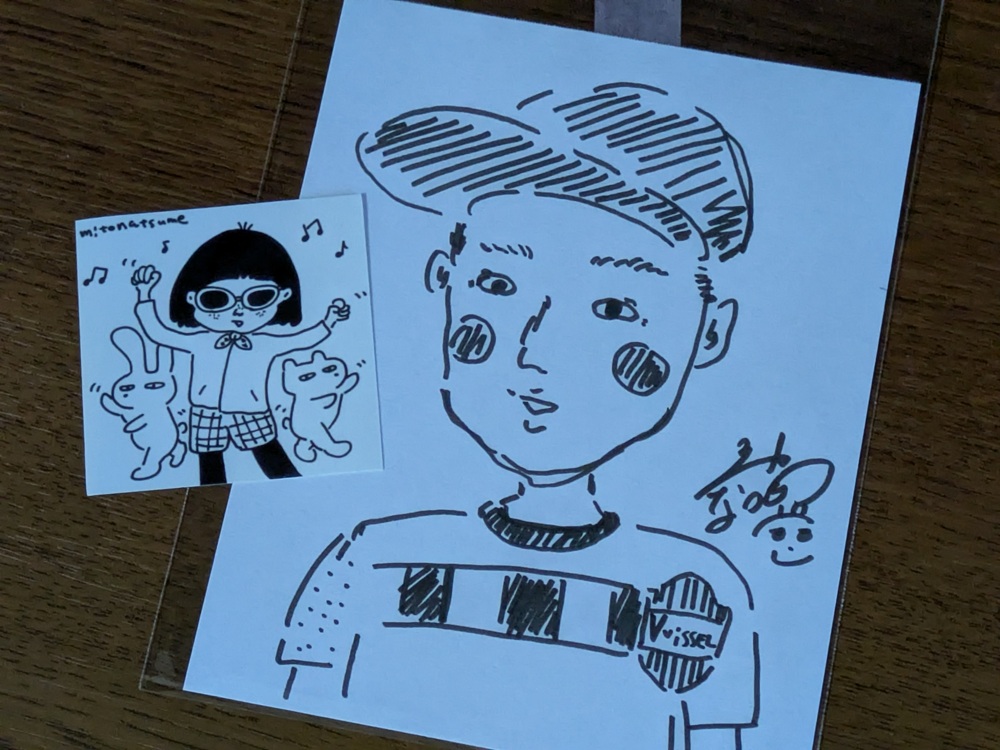 "三戸なつめさんが描いた似顔絵と、添えられたオリジナルステッカー"