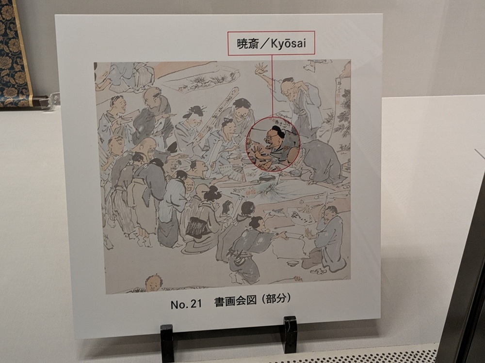 河鍋暁斎 書画会図 部分 暁斎自身の居場所を示す解説パネル