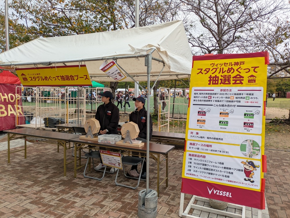 Bゲート前のスタグルめぐって抽選会ブースと景品案内の看板