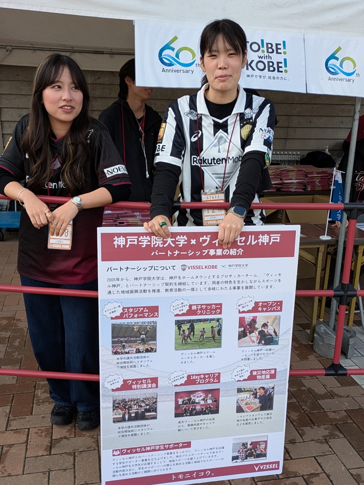 神戸学院大学とヴィッセル神戸のパートナーシップ事業紹介パネルと学生スタッフ